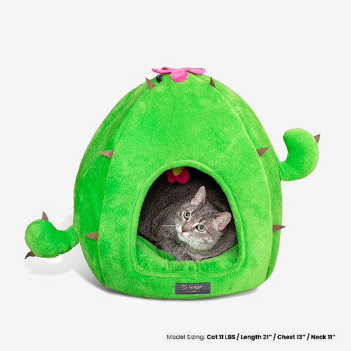 Green cactus-shaped pet bed with a cat peeking out on a white background