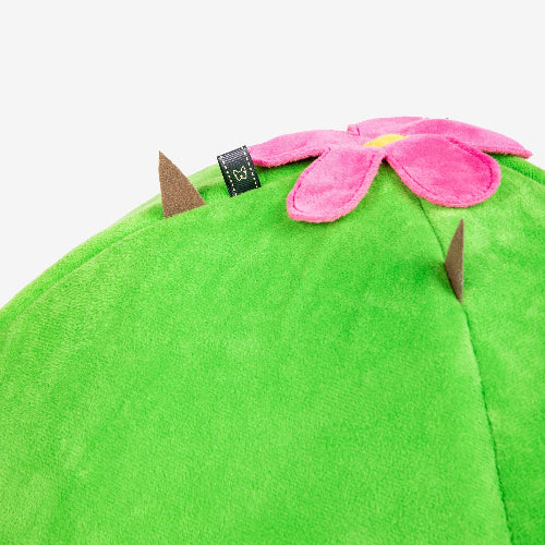 Green plush pet bed with a pink flower on a white background
