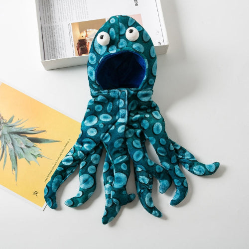 Blue octopus-shaped plush toy on a light gray surface with a magazine in the background.