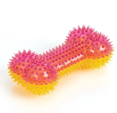 A translucent bone-shaped dog toy with a pink top half and a yellow bottom half, covered in raised spiky texture, shown on a white background.
